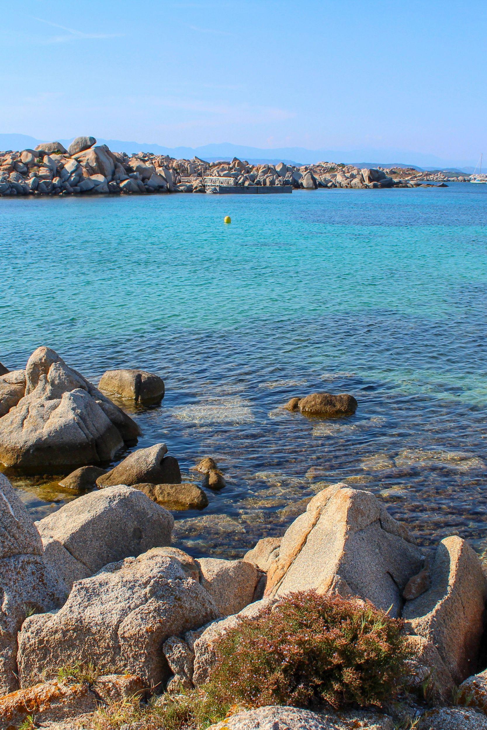 Bateau ancré dans une baie cristalline entourée de rochers granitiques en Corse