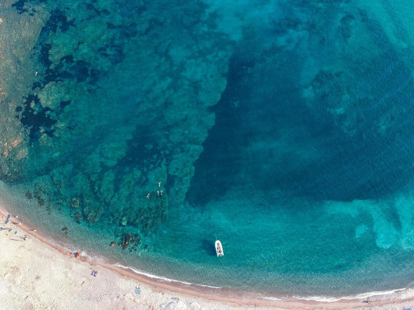 Vue aérienne d'une plage de luxe avec eaux turquoise et résidence côtière
