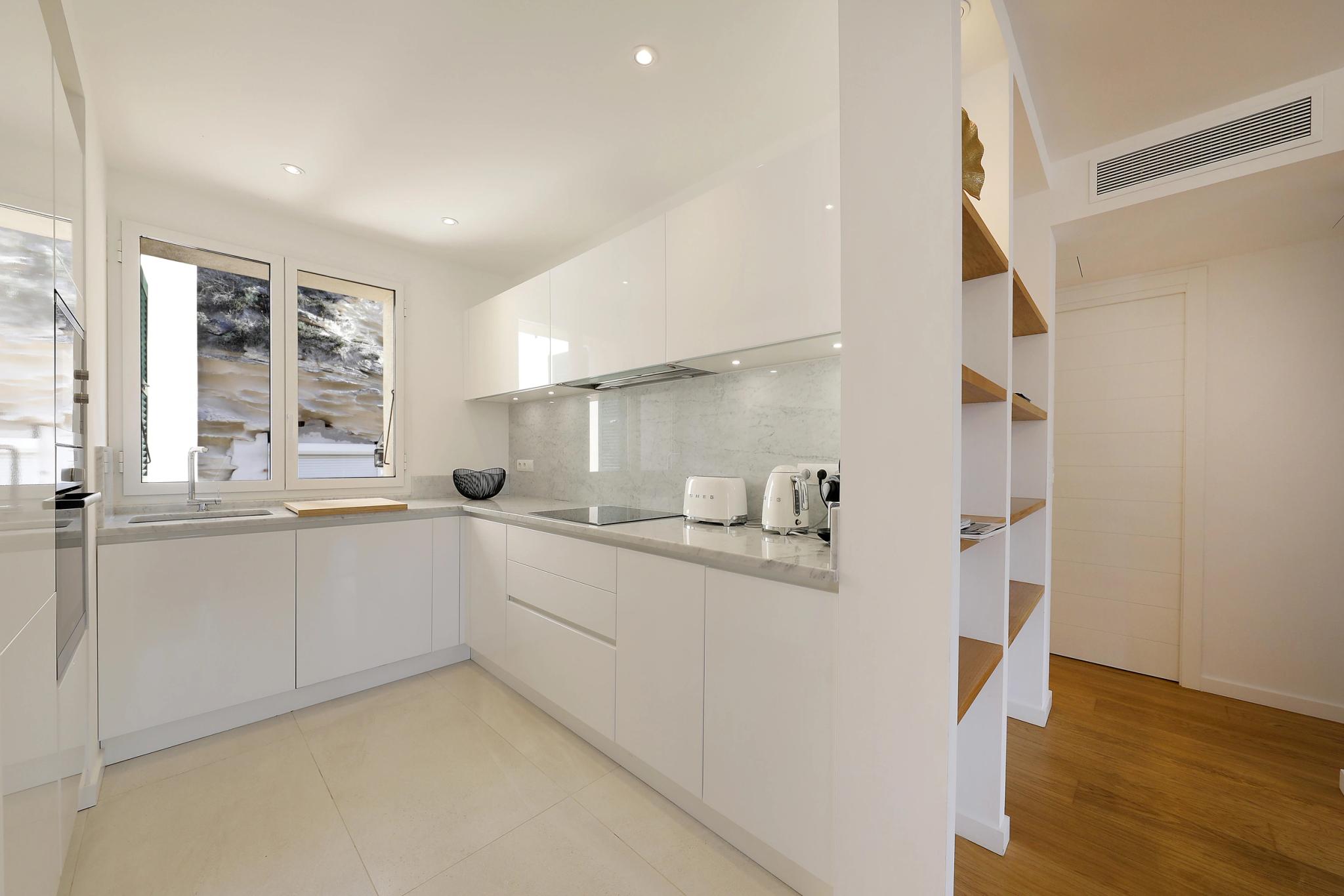 Cuisine moderne aux appartements de luxe avec mobilier blanc et plan de travail gris
