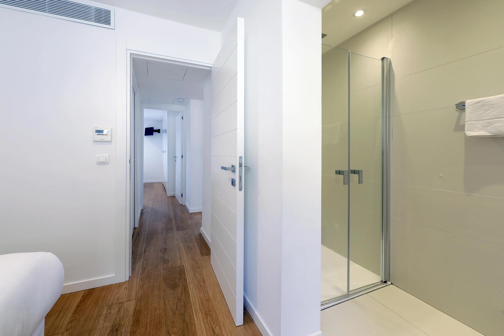 Salle de bain moderne d'appartements de luxe avec douche spacieuse et carrelage élégant
