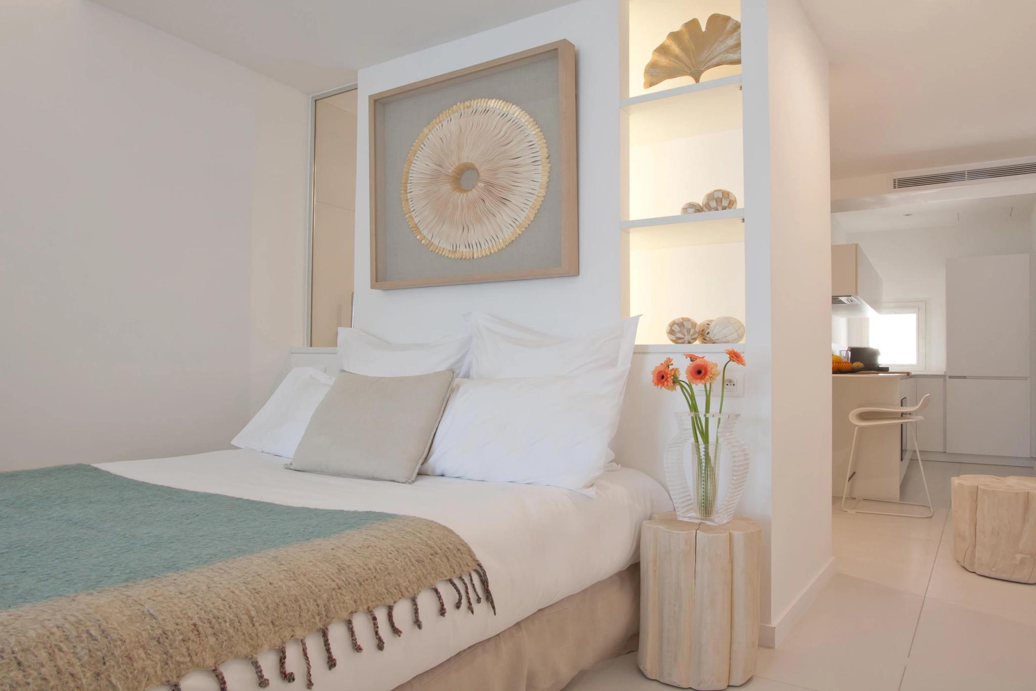 Chambre élégante d'appartements de luxe avec lit blanc, décoration épurée et mobilier contemporain