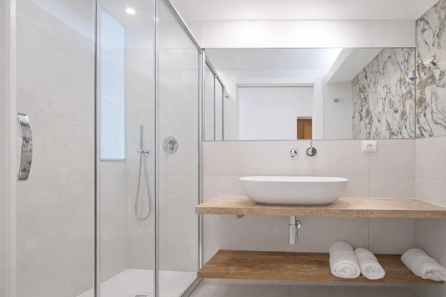 Salle de bain moderne des appartements de luxe avec douche, vasque et mobilier en bois