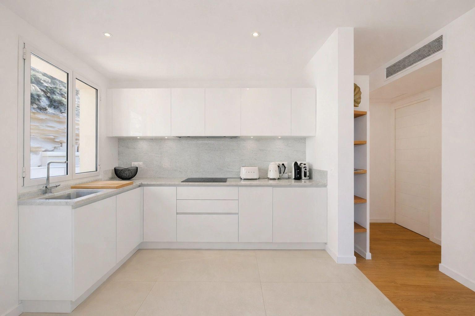 Cuisine moderne et élégante d'appartements de luxe avec mobilier blanc et plan de travail gris