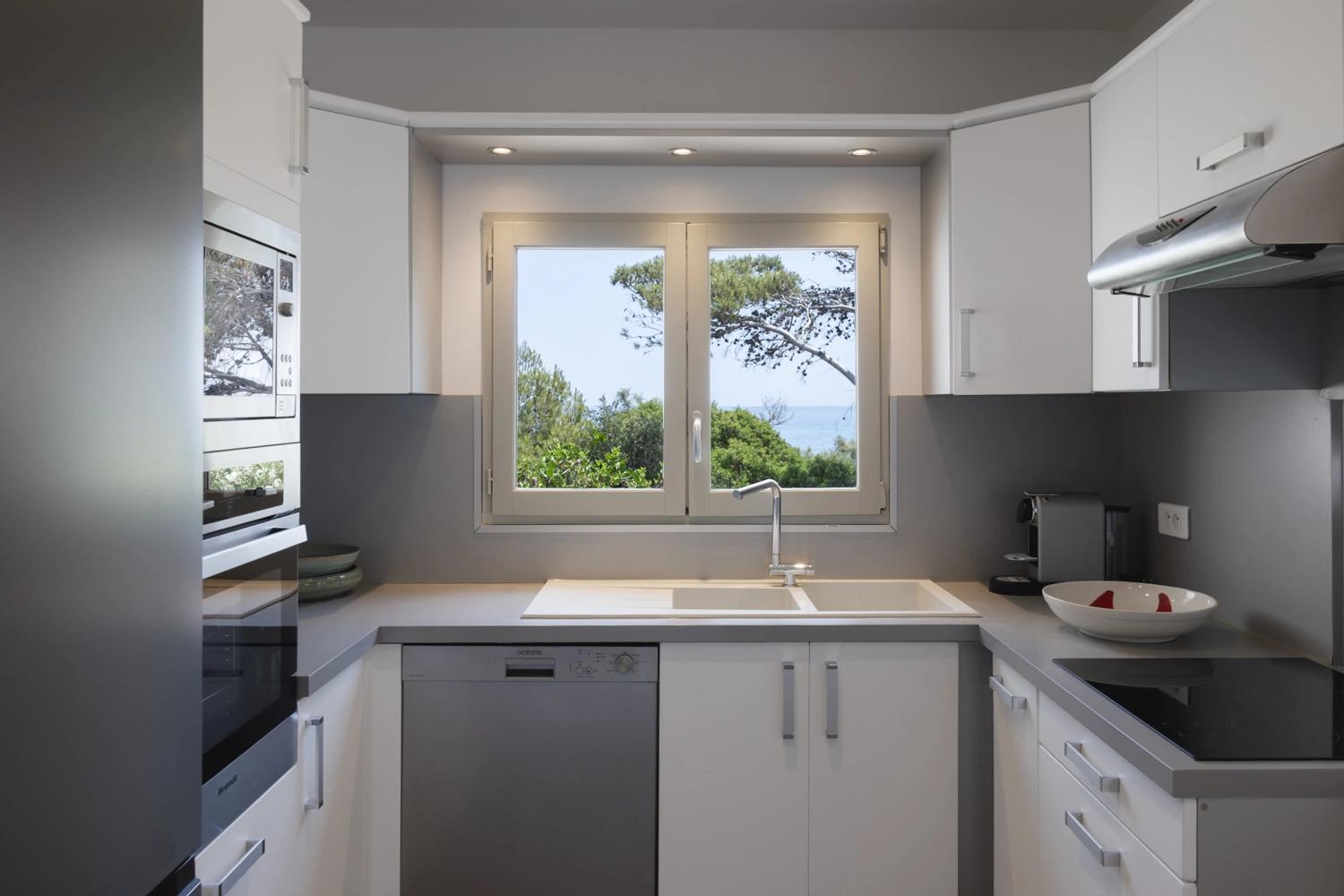 Cuisine moderne d'une résidence de luxe avec vue sur la mer et électroménagers haut de gamme