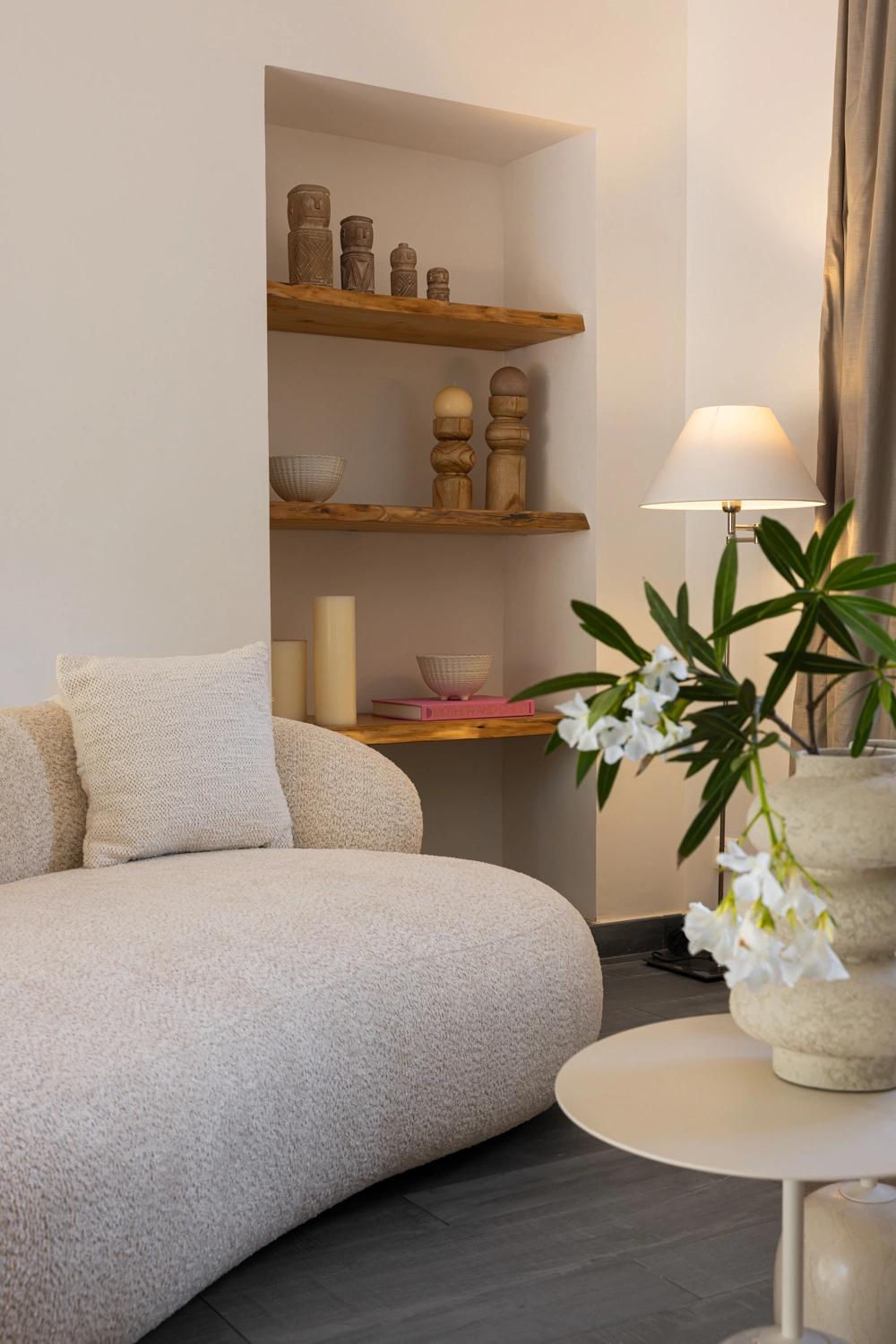 Salon élégant d'une résidence de luxe avec fauteuil beige et étagères décoratives