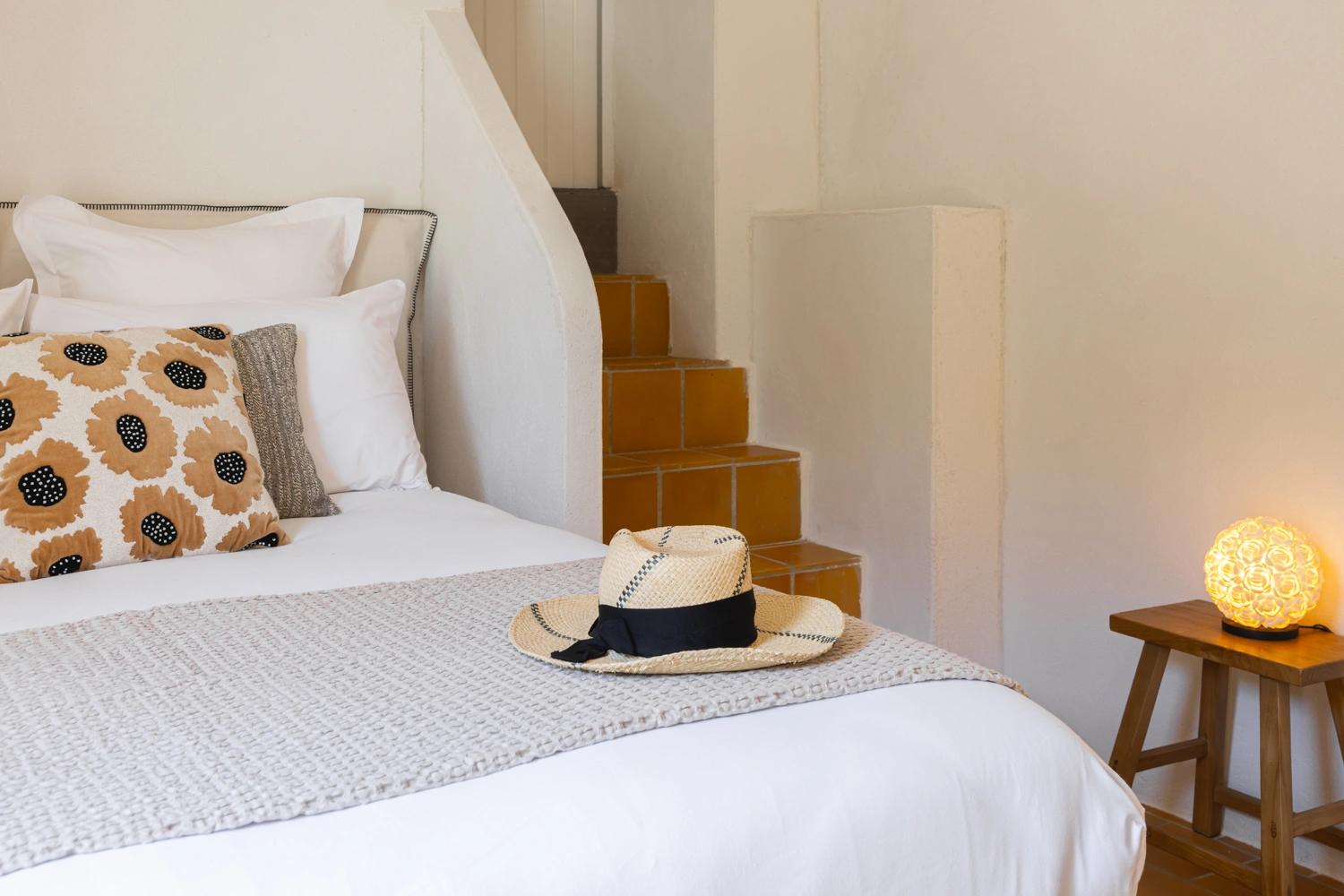 Chambre élégante d'une résidence de luxe avec lit blanc, décoration moderne et accessoires raffinés
