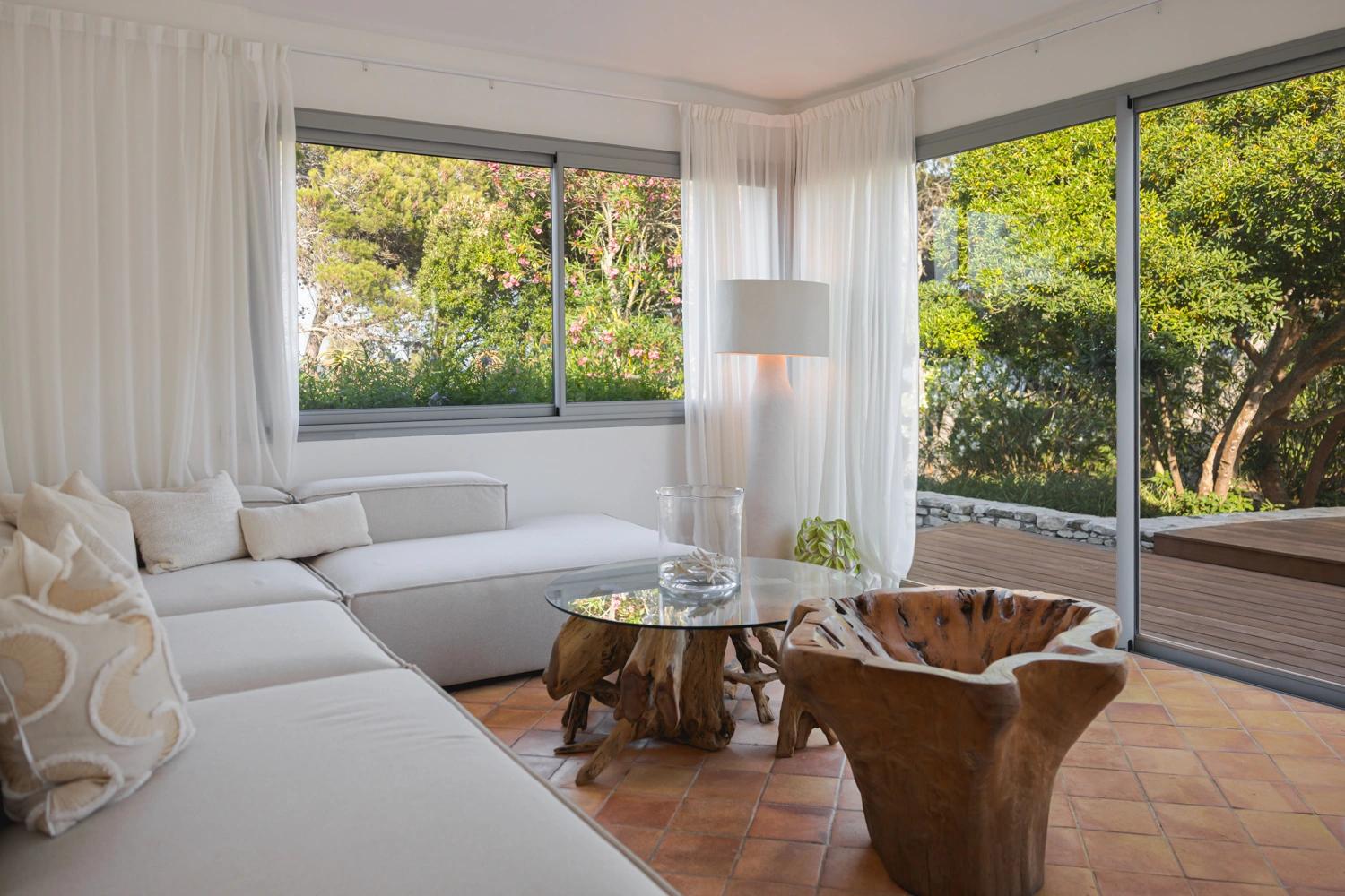 Salon moderne d'une résidence de luxe avec canapé blanc, baies vitrées et terrasse