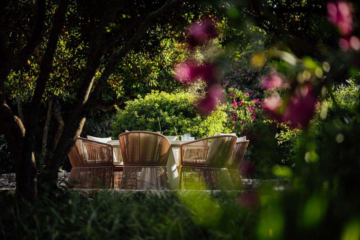 Résidence de luxe avec salon de jardin en rotin sous les arbres fruitiers