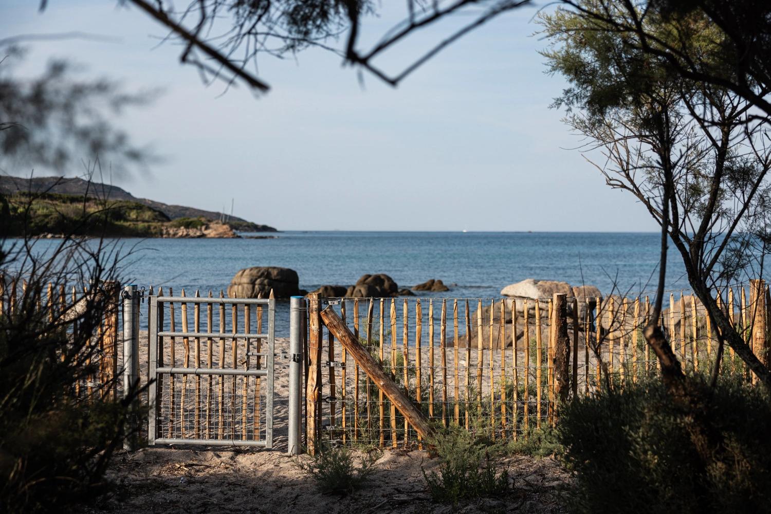 Portail d'accès à une plage privée de résidence de luxe avec vue sur la mer méditerranéenne